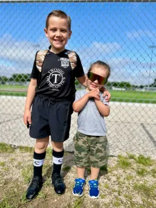 Two young boys posing outside