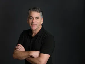 Doctor headshot posing with black gradient background